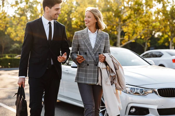 Photo of smiling man and woman talking and using cellphone — Stockfoto