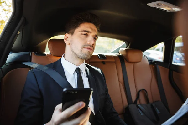 Imagen de joven caucásico hombre de negocios sosteniendo el teléfono celular en c — Foto de Stock