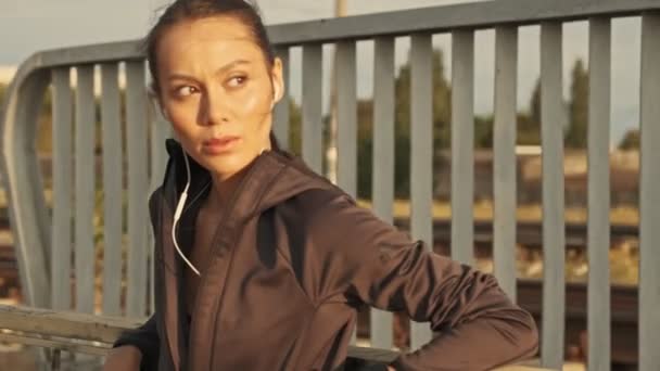 Sérieux Jolie Asiatique Sport Femme Dans Écouteurs Détente Regarder Autour — Video