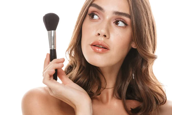 Portrait closeup of caucasian young woman holding makeup brush — 图库照片