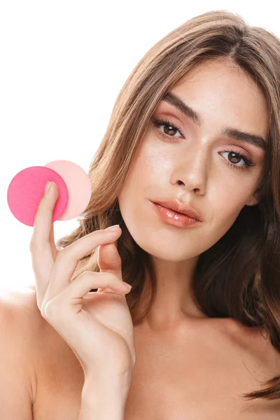 Portrait closeup of young woman applying cosmetics with makeup sponges — 图库照片