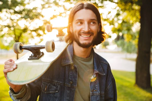 Handsome smiling young man spending time at the park — Stock Photo, Image