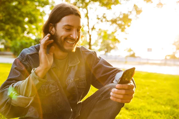 Smiling young man holding mobile phone