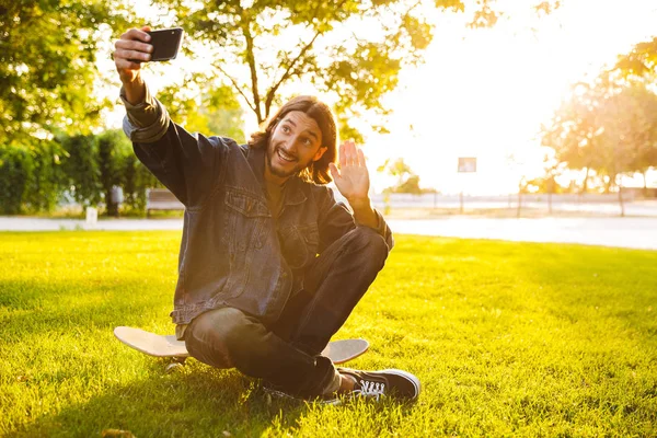 公園で時間を過ごすハンサムな笑顔の若い男 — ストック写真