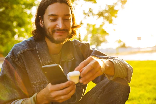 Leende ung man som innehar mobil telefon — Stockfoto