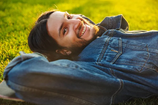 Schöner lächelnder junger Mann, der Zeit im Park verbringt — Stockfoto