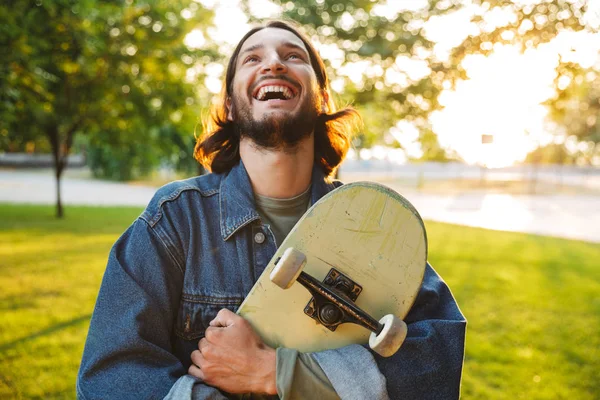 Knappe glimlachende jongeman brengt tijd door in het park — Stockfoto