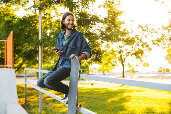 Красивый улыбающийся молодой человек проводит время в парке — стоковое фото