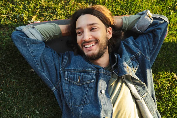 Bearded man lies on grass in nature park. — Stock Photo, Image