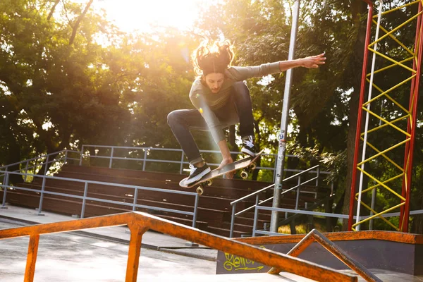 Guapo joven hipster patinando en una rampa de skate — Foto de Stock