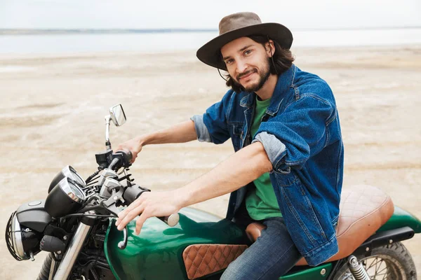 Positivo ottimista felice uomo motociclista sulla sua moto all'aperto su una spiaggia . — Foto Stock