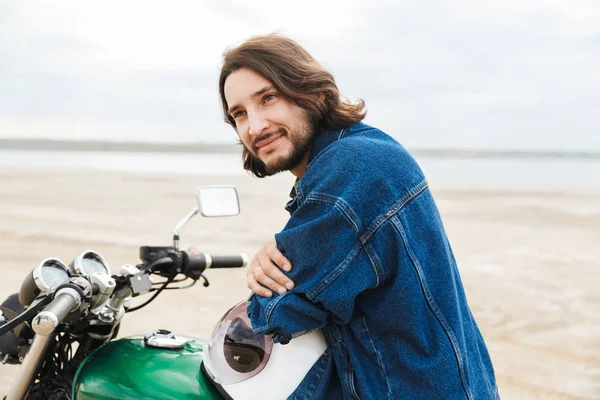 Positivo ottimista felice uomo motociclista sulla sua moto all'aperto su una spiaggia . — Foto Stock