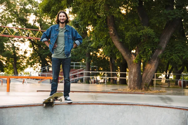 Knap jong hippie man schaatsen op een skate helling — Stockfoto