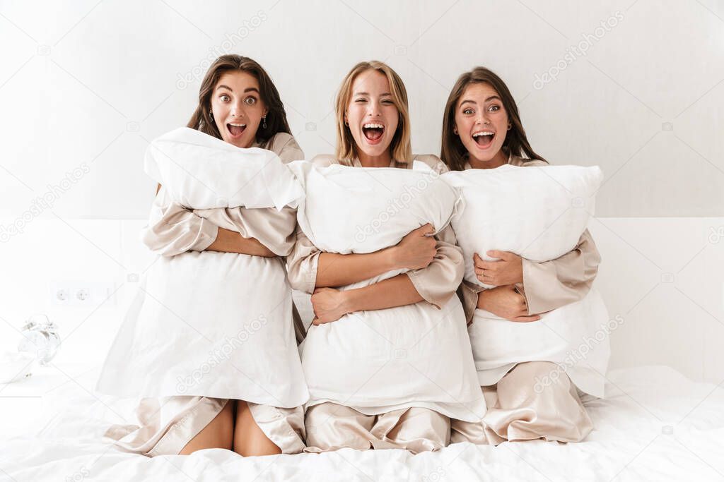 Girls women friends holding pillows.