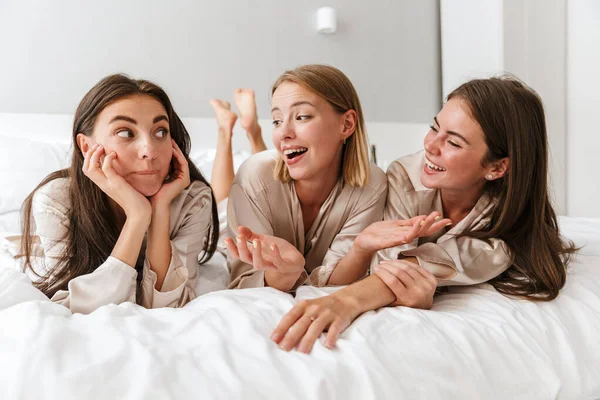Three cheerful girls friends wearing dressing gowns — 스톡 사진