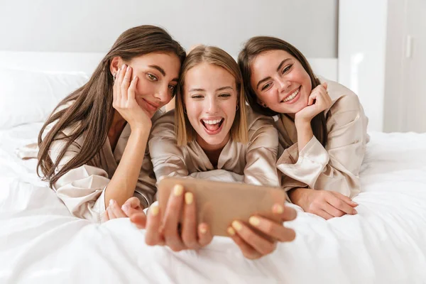 Tre ragazze allegre amiche che indossano vestaglie — Foto Stock