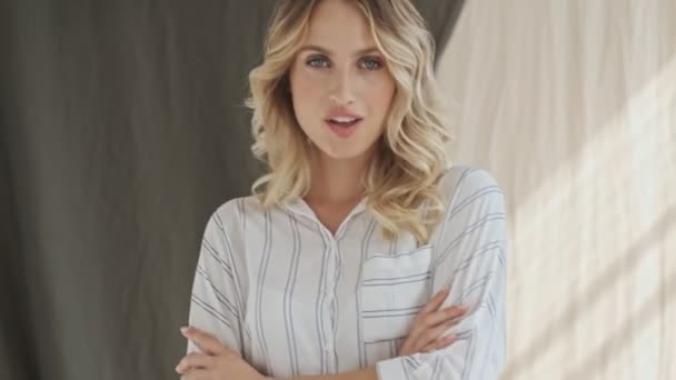 Красива Блондинка Позує Схрещеними Руками Студії Потім Вказує Пальцем Камеру — стокове відео