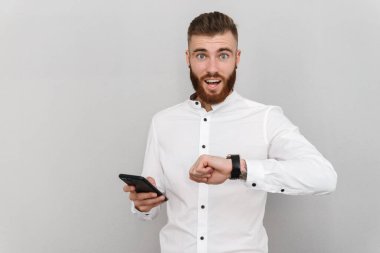 Akıllı kaset ve cep telefonu kullanan şaşırmış bir genç resmi