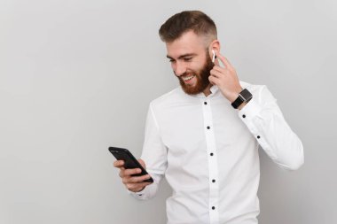 Kulaklık ve cep telefonu kullanırken gülümseyen genç adam görüntüsü