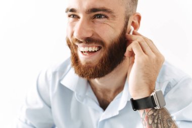 Kulaklıkla müzik dinleyen pozitif genç iş adamı.