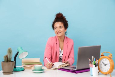 Çalışırken günlüğe neşeli bir kadın düşüncesi ve not alma görüntüsü