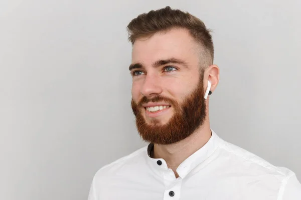 Imagen de hombre guapo alegre sonriendo y usando auricular — Foto de Stock