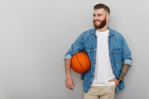 Bild av skäggig nöjd man som håller i basket och ler — Stockfoto