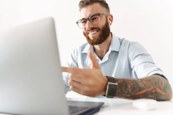 Веселый оптимистичный молодой бизнесмен, использующий ноутбук — стоковое фото