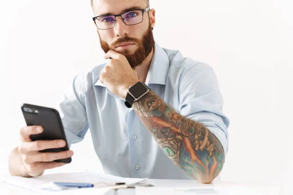 Soustředěný mladý podnikatel používající mobilní telefon. — Stock fotografie