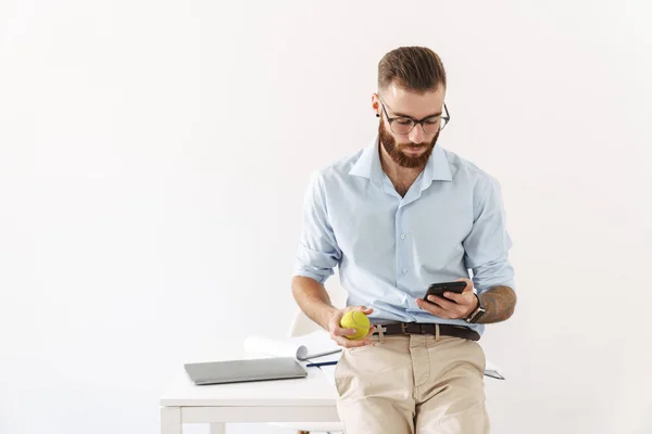 Soustředěný mladý podnikatel používající mobilní telefon — Stock fotografie