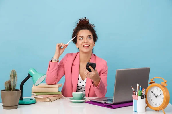 Immagine di una donna felice che sogna usando il cellulare mentre lavora alla scrivania — Foto Stock