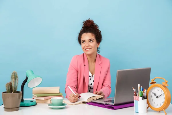 Imagen de la mujer alegre pensando y tomando notas en el diario mientras trabaja — Foto de Stock