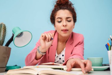 Düşünen bir kadının günlük tutarken okuyup not alması.