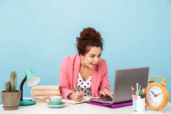 Imagen de la mujer excitada usando el portátil y tomando notas en el diario — Foto de Stock