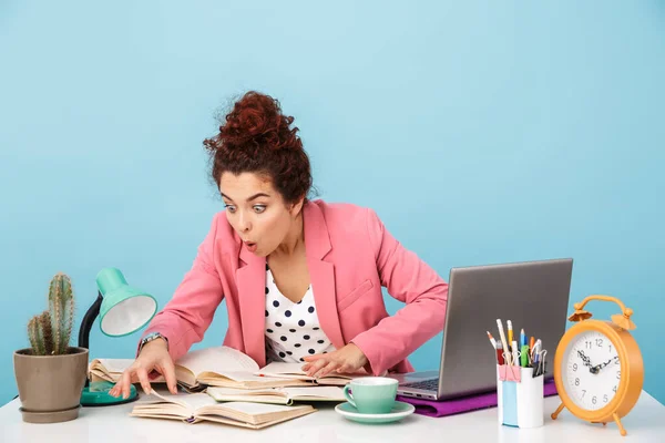 Immagine di una giovane donna sorpresa che legge libri mentre lavora — Foto Stock