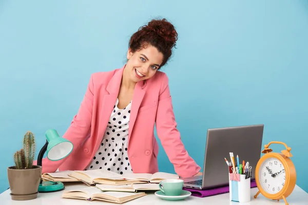 Immagine di una donna soddisfatta che sorride e guarda la macchina fotografica mentre lavora — Foto Stock