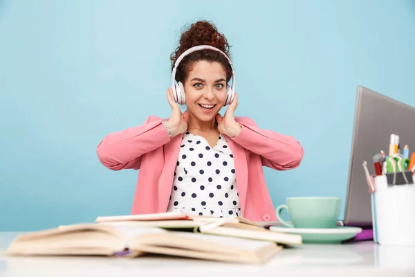 Image of smiling woman listening music with headphones while working — Stock Photo, Image