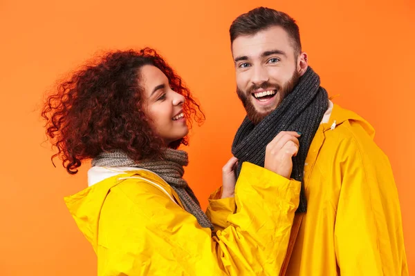 Amante casal posando em capas de chuva amarelas isolado — Fotografia de Stock