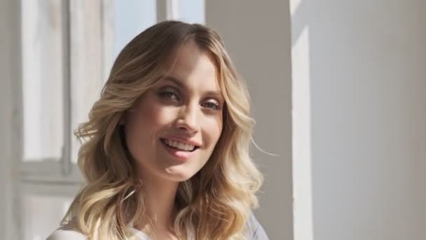 Jolie Femme Souriante Aux Cheveux Blonds Tient Près Fenêtre Tout — Video