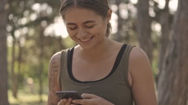 Glada Unga Vackra Sport Kvinna Med Hjälp Smartphone Parken Utomhus — Stockvideo