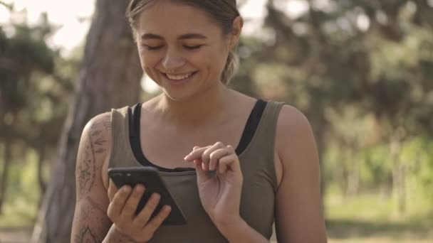 Glad Ung Söt Sport Kvinna Med Hjälp Smartphone Parken Utomhus — Stockvideo