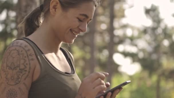 Sidovy Över Happy Ung Vacker Sport Kvinna Med Hjälp Smartphone — Stockvideo