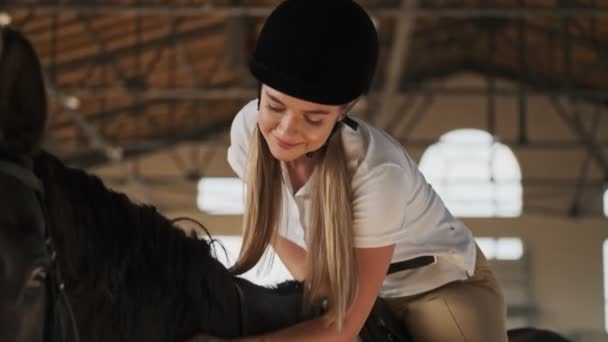 Menina Loira Bonita Está Acariciando Cavalo Enquanto Montá Estábulo Coberto — Vídeo de Stock