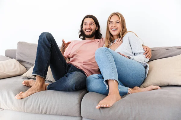 Couple on sofa watch tv film indoors at home.