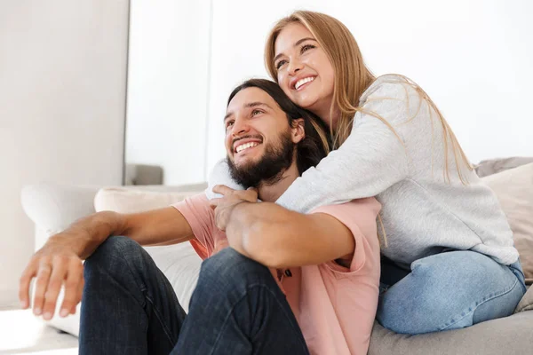 Любящая пара на диване смотреть телефильм — стоковое фото