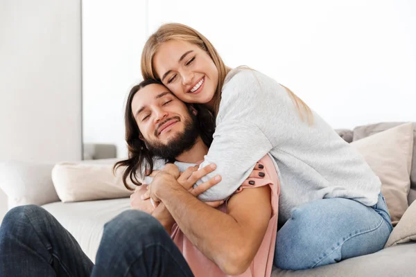 Joven pareja amorosa en sofá abrazo . — Foto de Stock