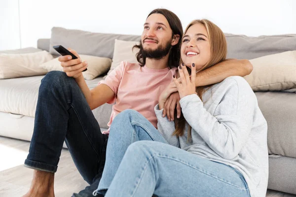 Pareja cariñosa en el sofá ver la película de televisión en el interior en casa . — Foto de Stock