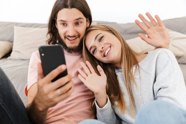 Happy lovely couple relaxing on a couch at home — Stock Photo, Image
