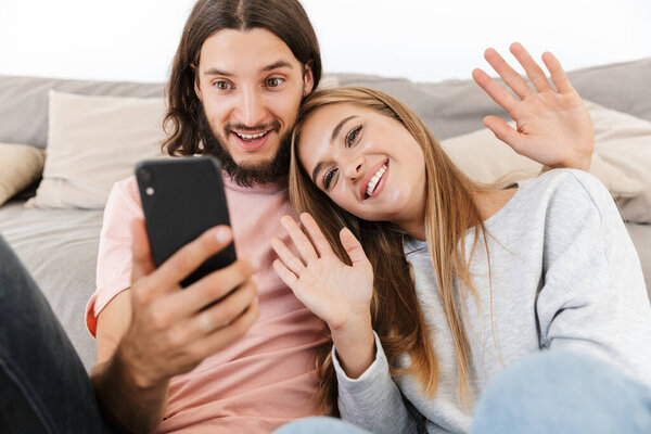Happy lovely couple relaxing on a couch at home