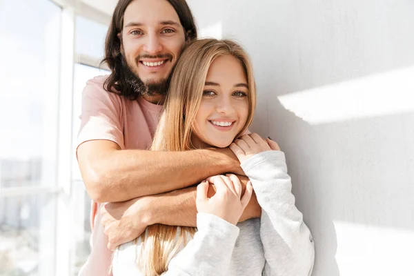 Beautiful lovely couple standing at the living room at the window — 스톡 사진